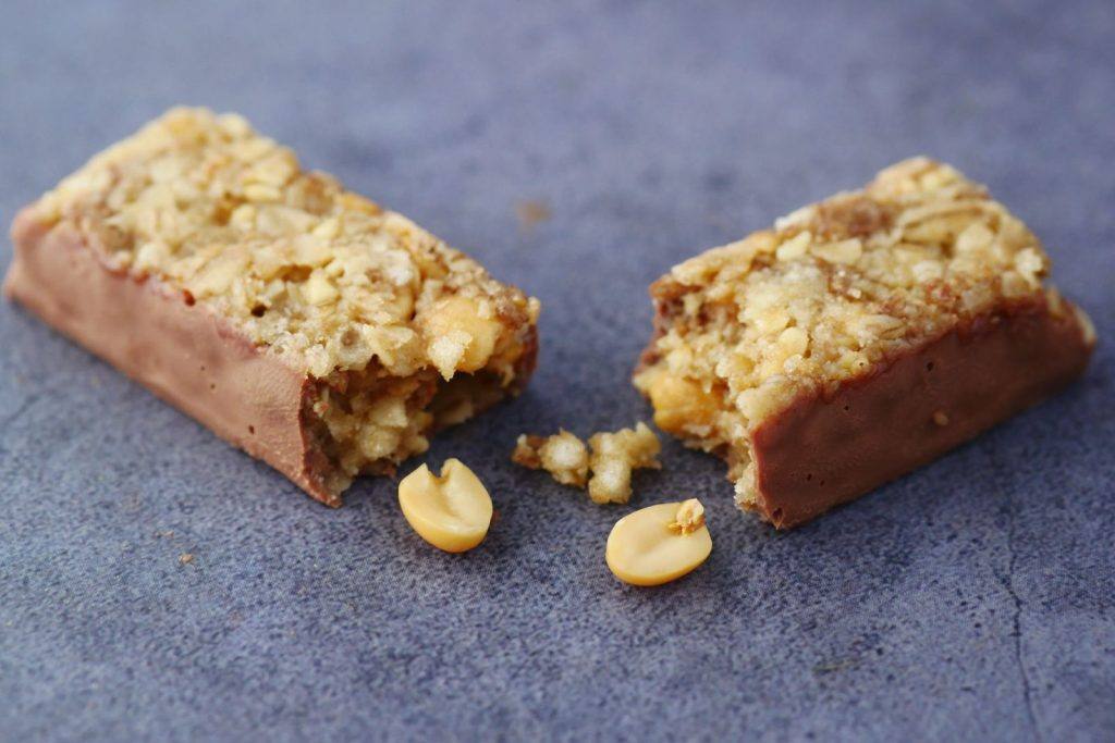 Two muesli bars with nuts on a blue background