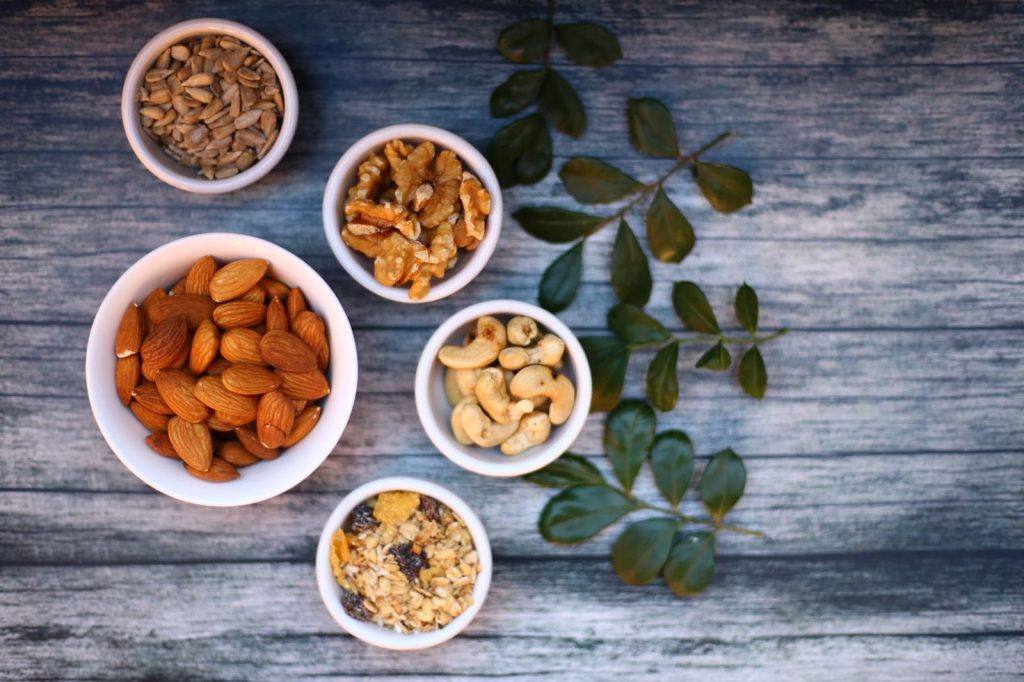 Small bowls of nuts and seeds on a wooden table